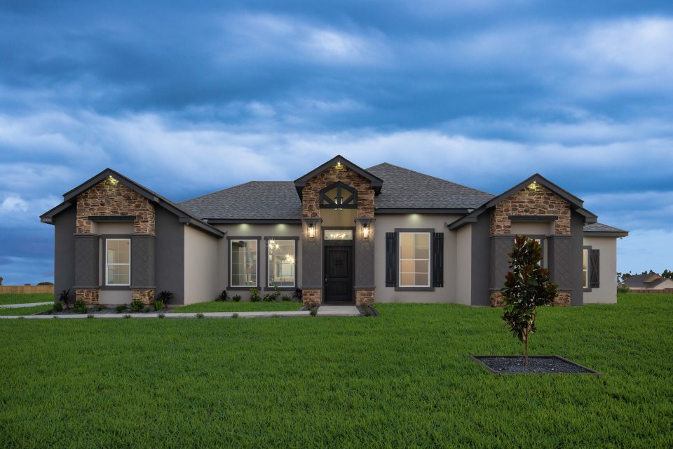 a large house with a tree and a grass field next to the yard