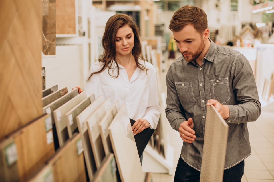 Young couple choosing tiles at building market