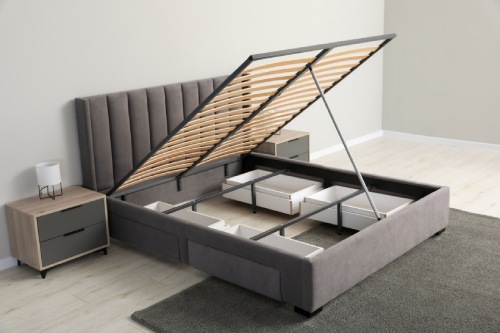 Comfortable bed with storage space for bedding under lifted slatted base in room