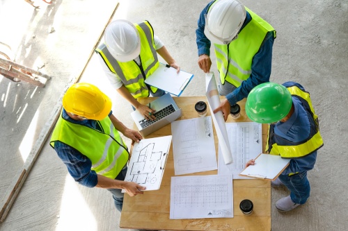 engineering teamwork meeting on site work,engineers project manager consultation meeting with coworker.concept of engineering or architecture working outdoors for a new real estate home project
