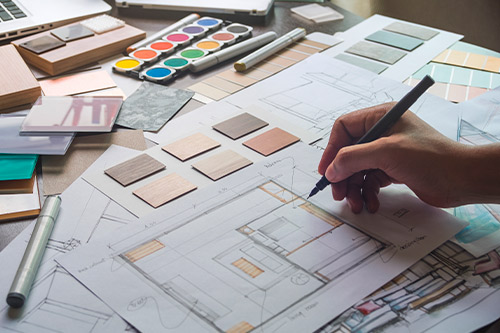 A designer collaborating on a project with a laptop, immersed in work within a modern office environment.