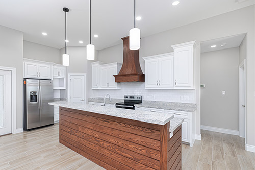  A modern kitchen featuring white cabinets and a wooden island, showcasing popular design trends.